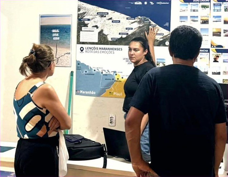 Equipe da TLM atendendo turistas no mapa da Rota das Emoções, no escritório em Barreirinhas