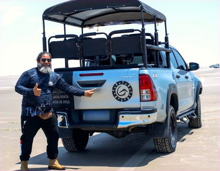 Guia da equipe ao lado do 4x4 usado nos passeios dentro dos Lençóis Maranhenses